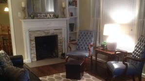 A living room with a fireplace, two armchairs, a coffee table, and a patterned rug. - Modern Home in The Center of it All -  Location, Location, Location!  (Nashville)