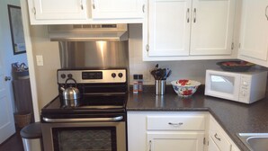 A kitchen with stainless steel appliances, white cabinets, and a microwave. - Modern Home in The Center of it All -  Location, Location, Location!  (Nashville)