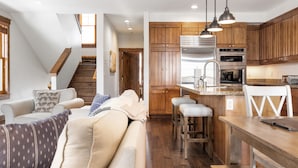 A modern kitchen with wooden cabinets, stainless steel appliances, and a bar area. - Outpost: Love Ridge 252 - Spacious, Air Conditioned (Jackson)