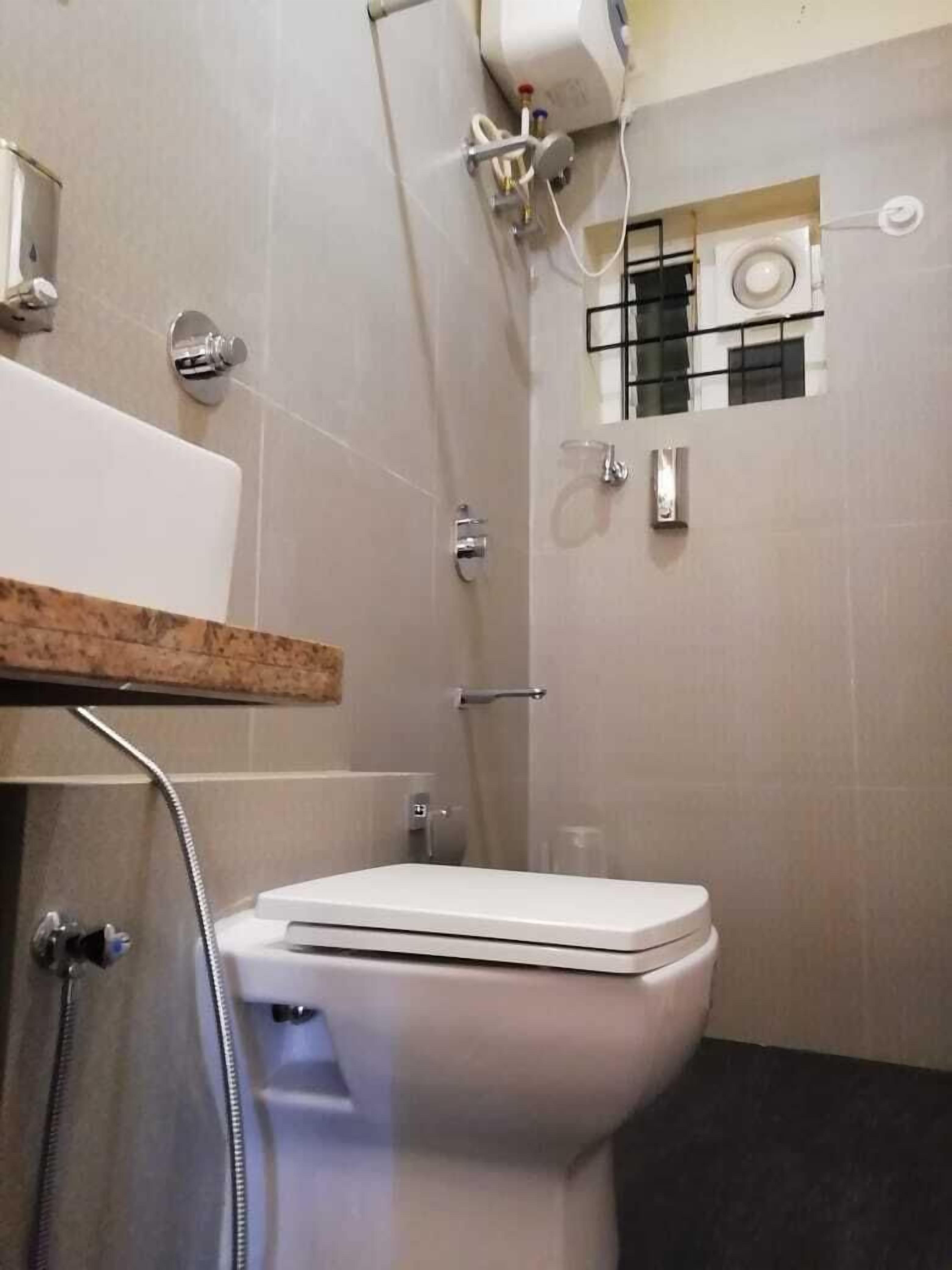 A modern bathroom with a toilet, a shower, and a sink.