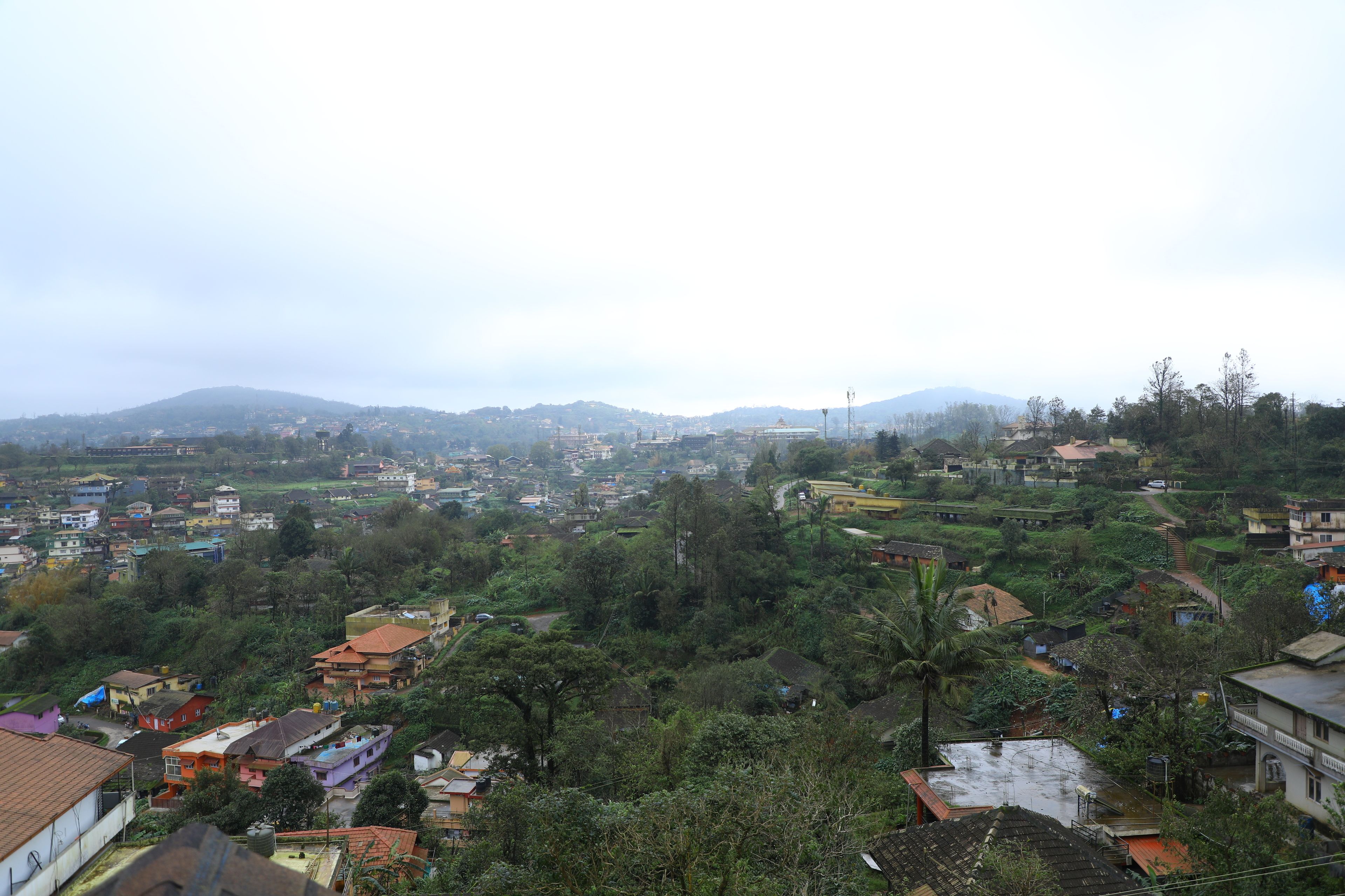 Un barrio residencial con casas, árboles y un paisaje montañoso al fondo.