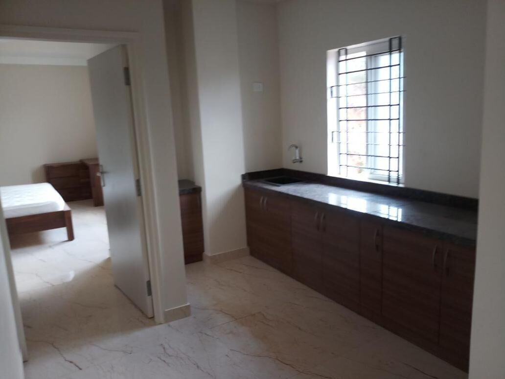A kitchen with a window, a sink, and cabinets.
