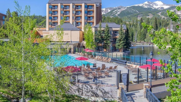 A hotel with a pool area, surrounded by trees and a mountain view. - 7231^ Gorgeous View - Ski-In/Out - 4 Season Pool! (Breckenridge)