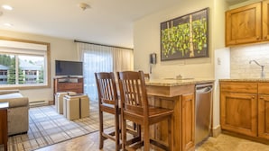 A modern kitchen with wooden cabinets, a built-in dishwasher, and a large window offering a view of the outside. - 7231^ Gorgeous View - Ski-In/Out - 4 Season Pool! (Breckenridge)