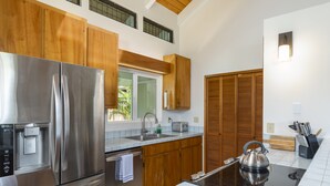 Une cuisine moderne dotée d’appareils électroménagers en acier inoxydable, de meubles en bois et d’un four encastré.