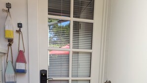 A white door with a frosted glass panel, a keyhole, and a doorbell. - Cozy Private Beach Bungalow, New Hot Tub,  1 Dog ok, 3 short Blocks To Beach. (Santa Cruz)
