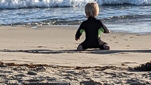 A child sitting on a sandy beach facing the ocean. - Cozy Private Beach Bungalow, New Hot Tub,  1 Dog ok, 3 short Blocks To Beach. (Santa Cruz)