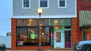 A two-story building with a storefront labeled 'Oak's Eatery.' - Stay in downtown Three Oaks overlooking the main street!  (Three Oaks)