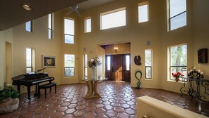 A spacious room with a piano, a glass table with flowers, and a tiled floor. - Hacienda near Ritz Carlton 360 views on 5 ac, all bdrms ensuite bathrms (Marana)