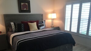 A bedroom with a bed, nightstands, a lamp, and a window with blinds. - Beautifully Refurbished villa in an exciting active retirement community. (The Villages)