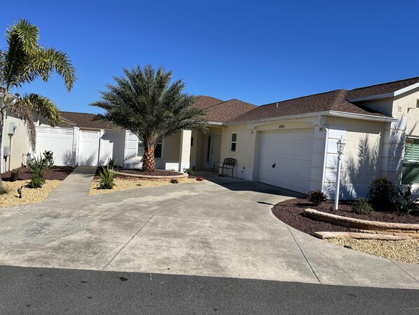 Zona residencial con casas, un camino de acceso y una palmera.