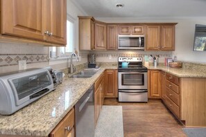 Fridge, microwave, oven, stovetop - Experience family fun at Turtle Time, a 4-bedroom home in Oak Island, NC. (Oak Island)