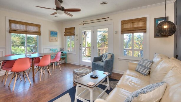 A spacious living area with a dining table, chairs, a sofa, and a ceiling fan. - Experience family fun at Turtle Time, a 4-bedroom home in Oak Island, NC. (Oak Island)