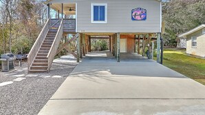 A two-story building with a covered walkway, a staircase, and a sign reading "Turtle Time". - Experience family fun at Turtle Time, a 4-bedroom home in Oak Island, NC. (Oak Island)