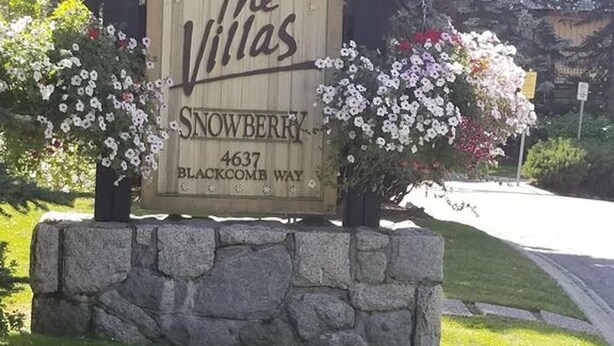 En träskylt med texten ”The Villas Snowberry” vid adressen 4637 Blackcomb Way.