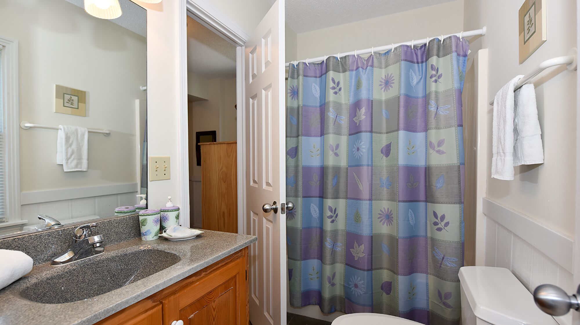 Une salle de bain avec un lavabo, un miroir et des toilettes.