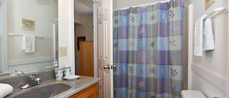 Une salle de bain avec un lavabo, un miroir et des toilettes.