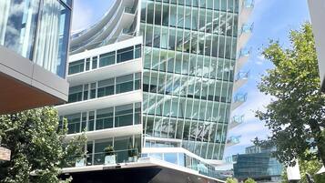 Un bâtiment moderne doté d’une façade en verre et de nombreux balcons.