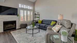 Un salon avec une cheminée, un canapé, une table basse et un téléviseur.
