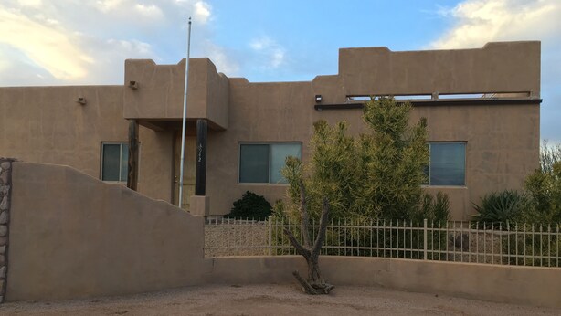 A modern building with a flat roof, a metal fence, and a small tree in the foreground. - Nestled in the Superstition Mountains! Amazing views! (Apache Junction)