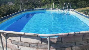 Enjoy a refreshing swim in the pool surrounded by a serene landscape.