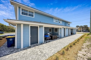 A two-story house with a covered porch, a garage, and a paved driveway. - PRIME LOCATION! Coastal Blue #4 Close To Amelia Island Gems! (Amelia Island)