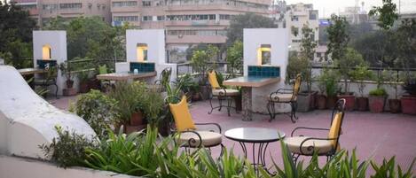 A rooftop terrace with outdoor seating and potted plants.