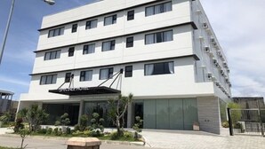 A modern hotel with a flat facade, multiple windows, and a sign indicating it is a hotel. - Capital O 827 Speciale Hotel (Rosario)