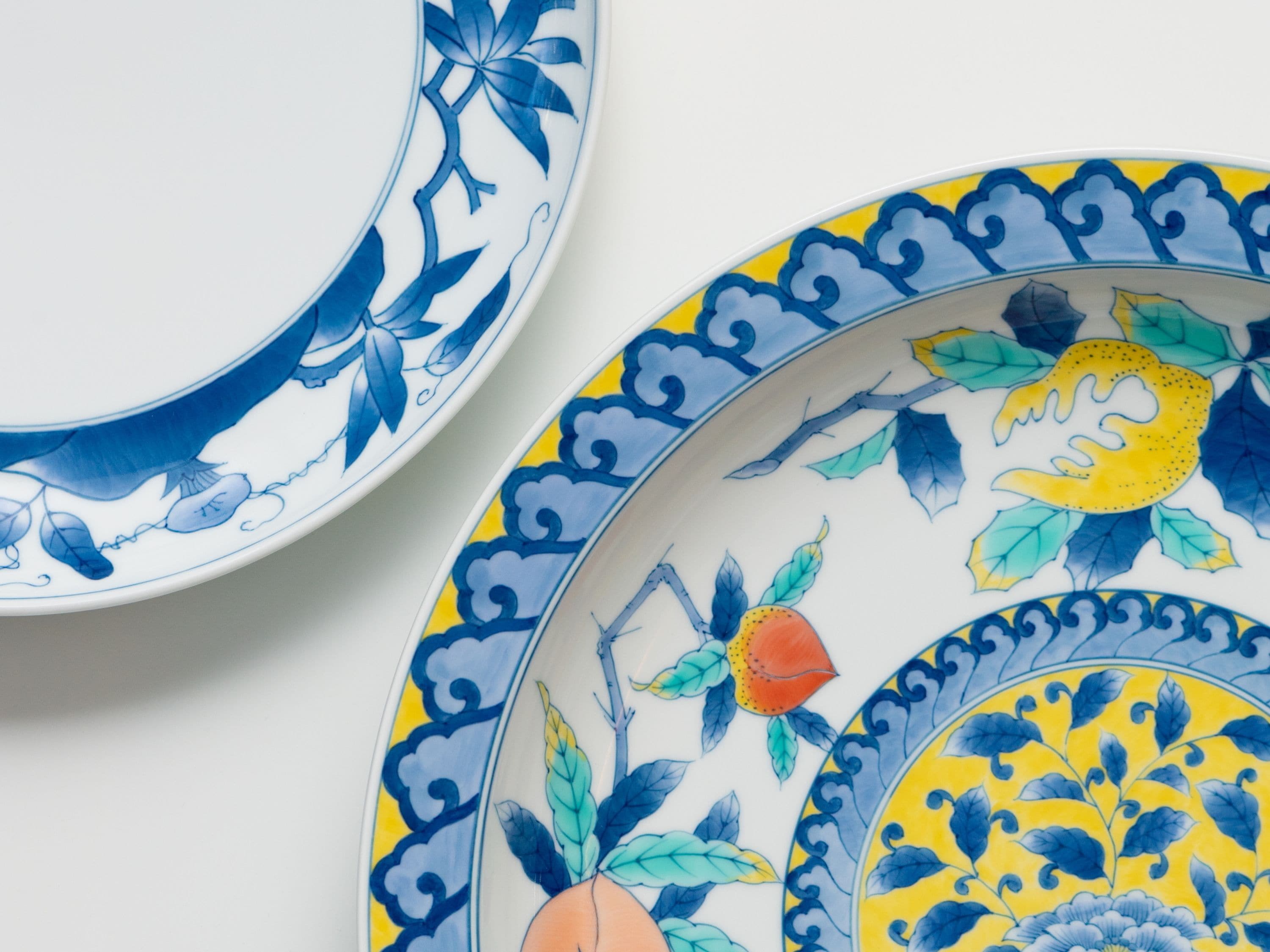 Dos platos de cerámica con diseños florales azules y amarillos detallados.