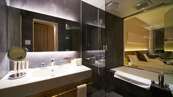 Un bagno moderno con uno specchio grande, una doccia e una vasca da bagno.