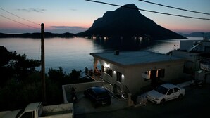A building with a balcony overlooking a body of water and a mountain in the background. - Hyperion Hotel Kalymnos (Kalymnos)
