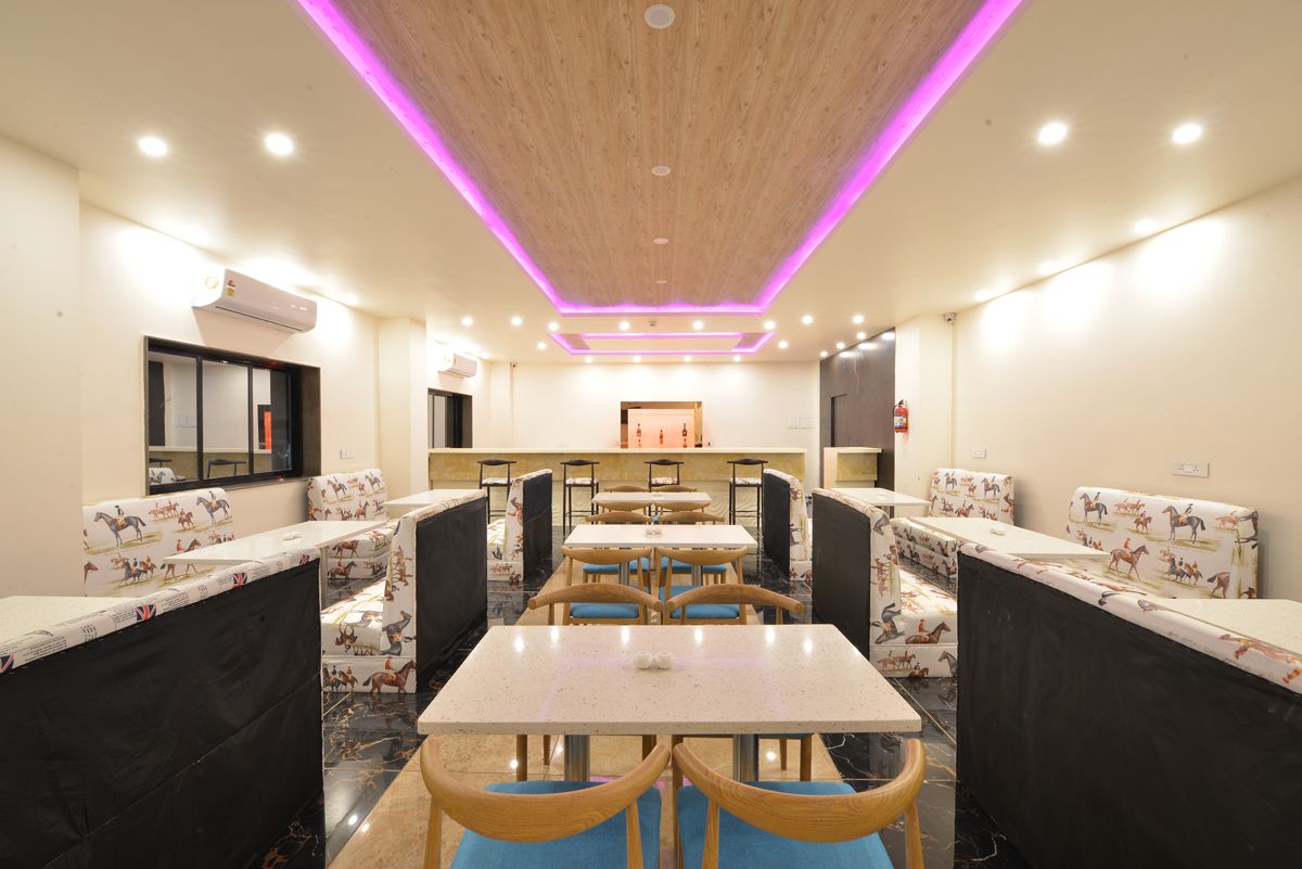 Ein Restaurant mit Sitzecken und Tischen, einer Holzbalkendecke mit LED-Beleuchtung und einem Feuerlöscher an der Wand.