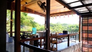 Una terraza de madera con un ventilador, una mesa y una silla azul.