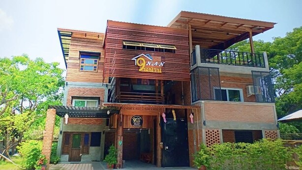Un edificio de dos pisos con un letrero llamativo que dice '9 Nand Restaurant'.