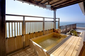A wooden deck with a hot tub and a view of the ocean. - Shiosai Kirara Shokichi (Ako)
