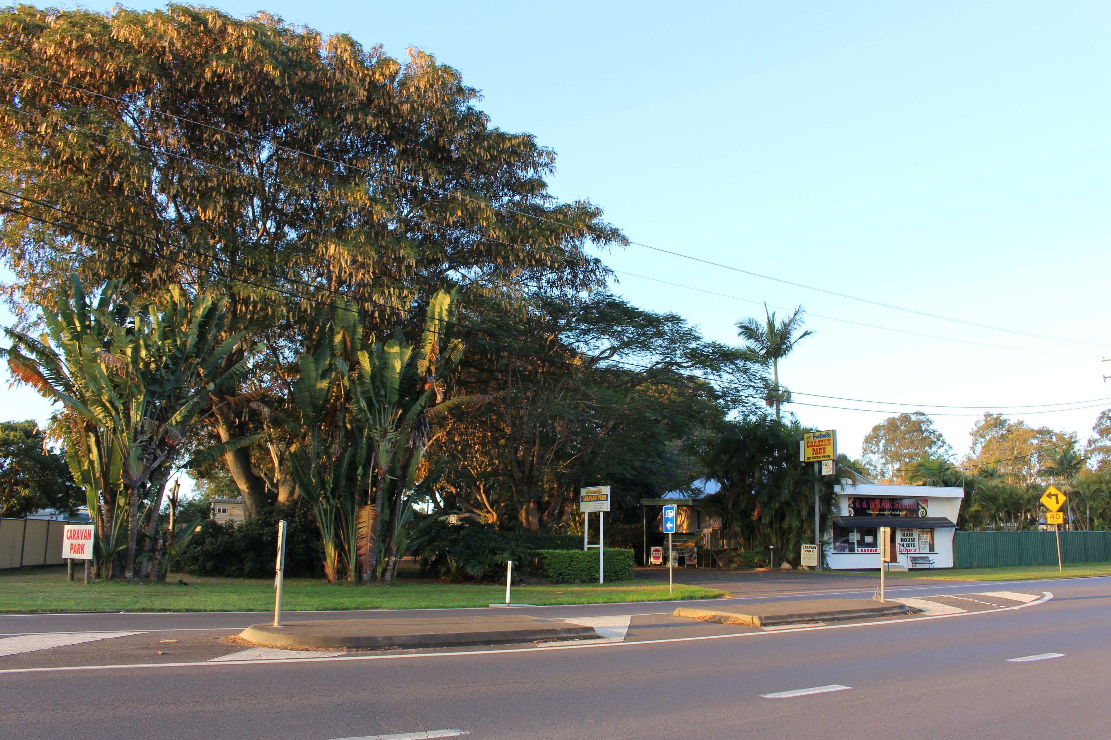 Vista de la calle con un restaurante llamado "R. D. Bean's" y un letrero que dice "Caravan Park".