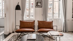Un salon moderne avec deux canapés en cuir, une table basse ronde et un lampadaire.