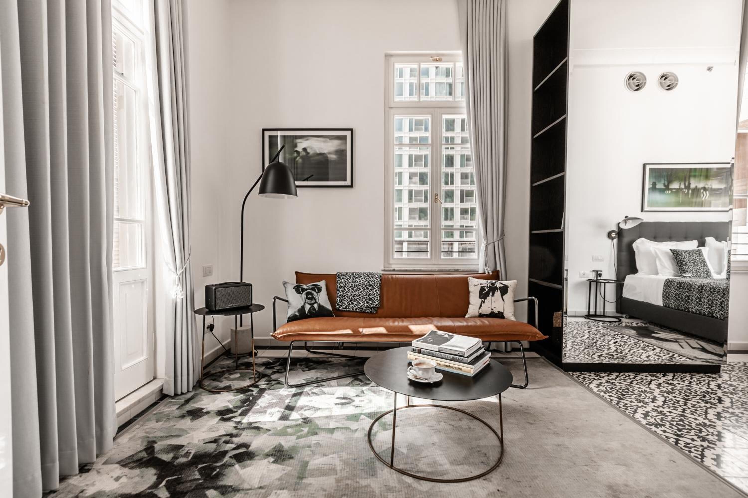 Una sala de estar moderna con un sofá, una mesita de centro y un ventanal grande.