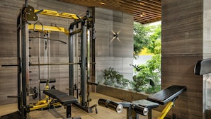 A gym with a squat rack, bench press, and various weight machines.