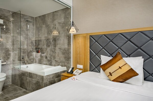 A modern bathroom with a glass-enclosed shower, a bathtub, and a vanity with a mirror.
