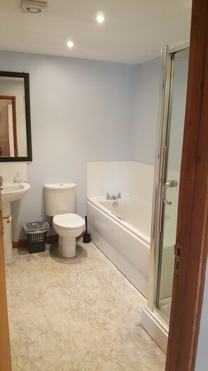 A bathroom with a toilet, sink, and bathtub. - Coldham Cottages (Bedford)
