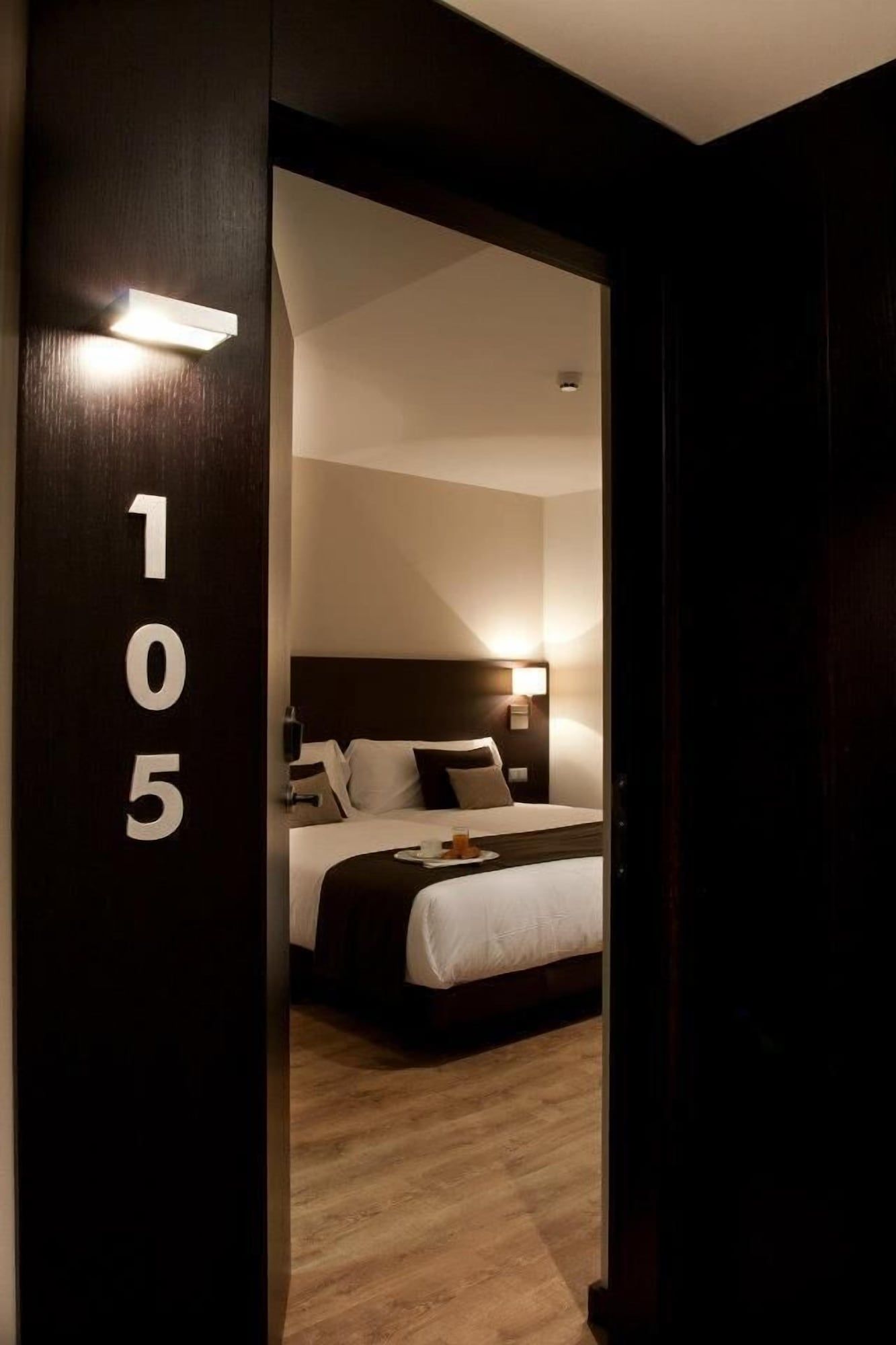 Een hotelkamer met een bed, nachtkastje en een bedtafel.