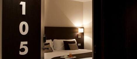 Een hotelkamer met een bed, nachtkastje en een bedtafel.