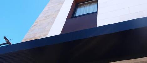 Een modern hotelgebouw met een bord waarop 'HOTEL PALOMA' staat.