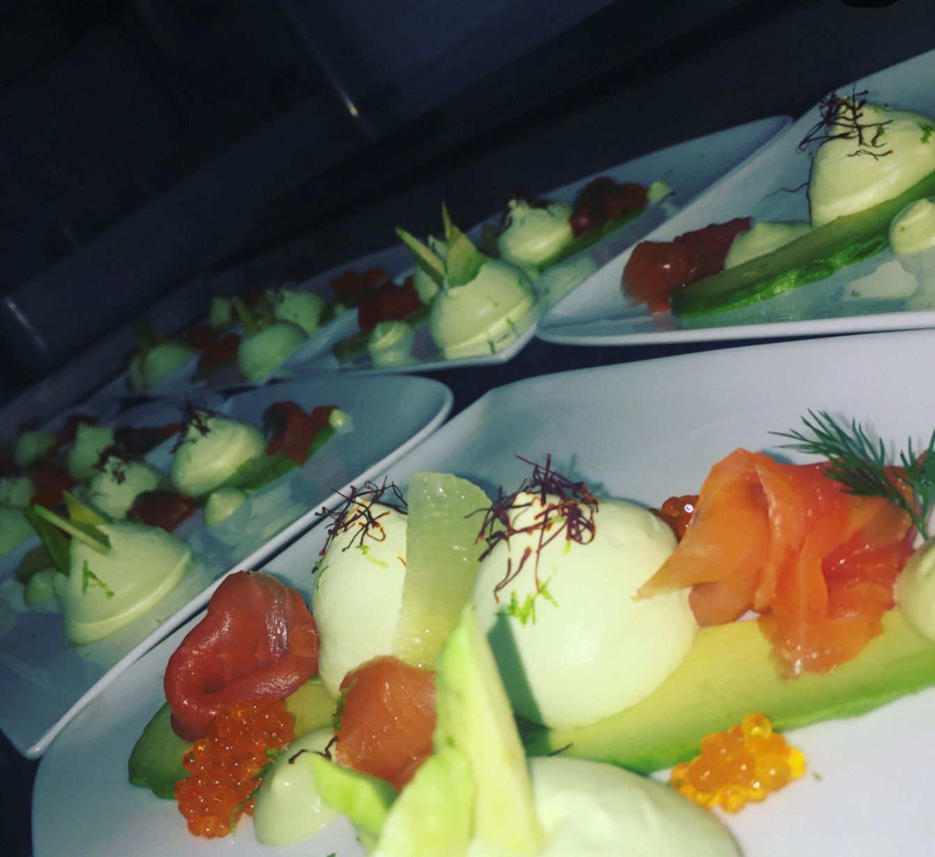 A series of appetizers arranged on plates, including smoked salmon, caviar, and garnishes.