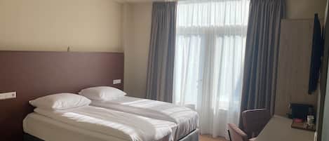 Een hotelkamer met een bed, een bureau en een stoel.