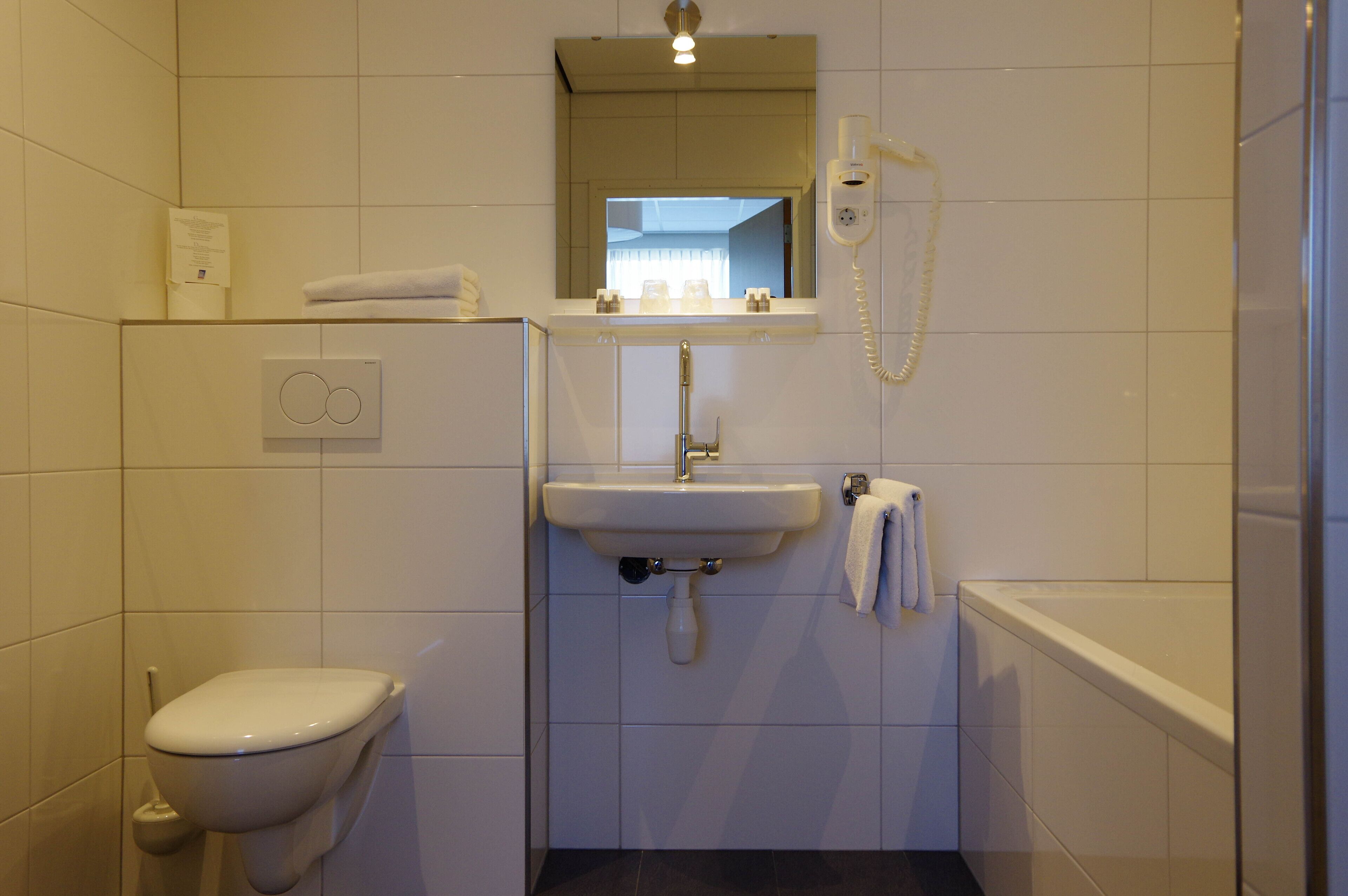 A bathroom with a toilet, sink, and bathtub.