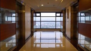 Un ascensor espacioso y moderno con amplias ventanas que ofrecen vistas despejadas de la ciudad.