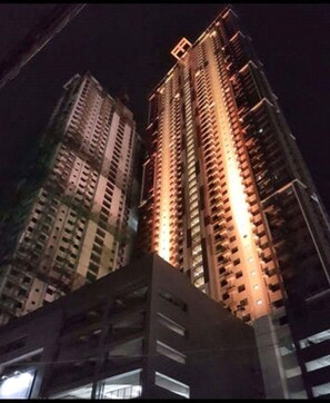 Deux immeubles de grande hauteur, la nuit, avec des fenêtres illuminées.