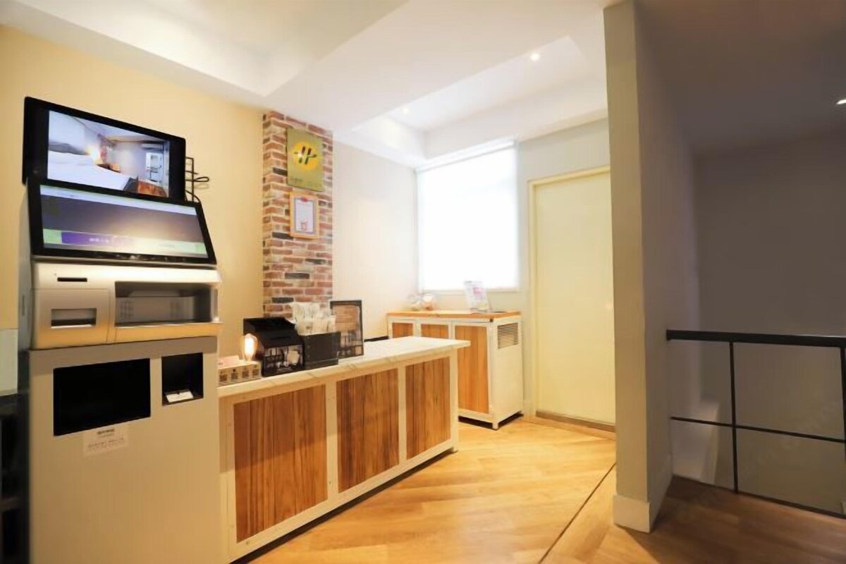 A modern kitchen with a built-in microwave, a coffee machine, and a television mounted on the wall.